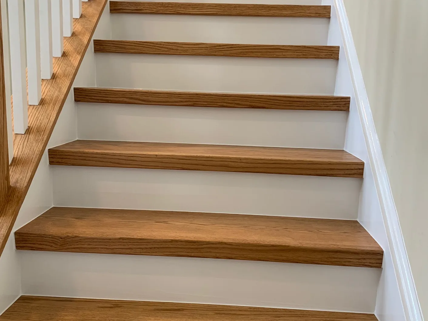Red oak stair treads with white risers on a refinished New Jersey staircase